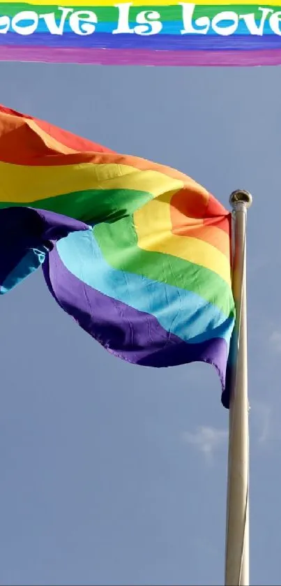 Rainbow Pride flag waving against a clear blue sky.