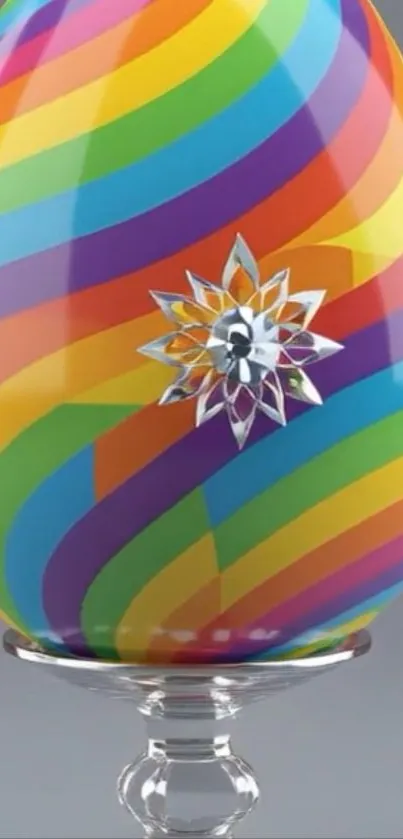 Rainbow-striped egg with decorative floral accent on a grey background.