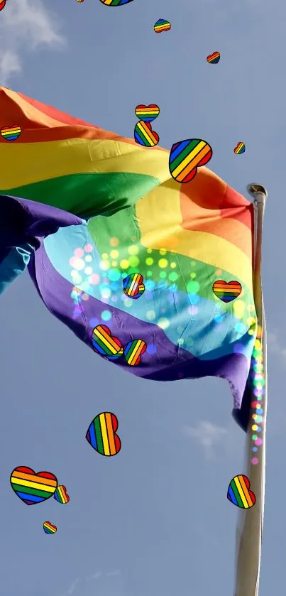 Rainbow flag with colorful hearts against a clear blue sky.