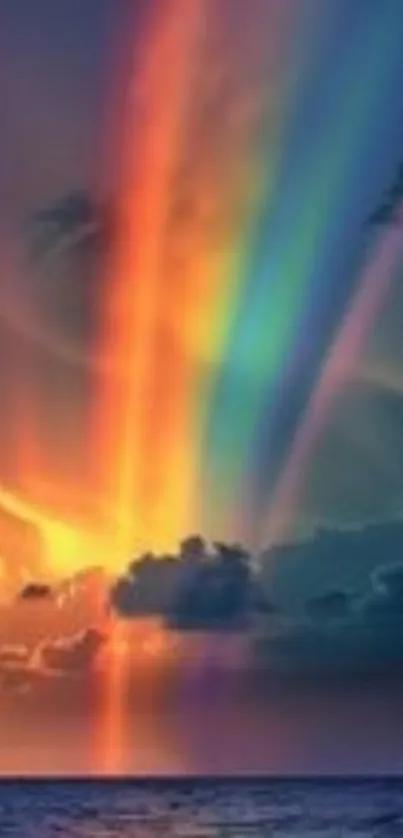 Colorful sunset with rainbow over ocean waves.