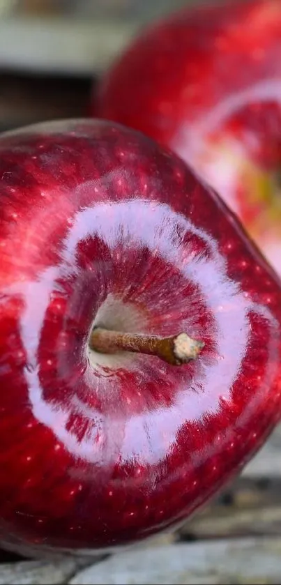 Close-up shot of a vibrant red apple on a rustic surface.