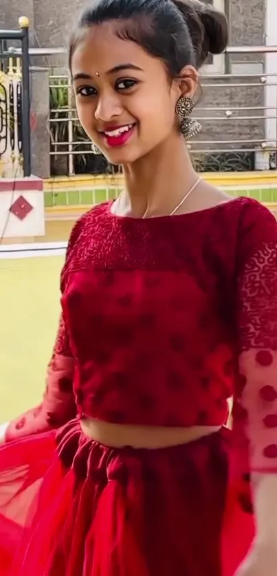 Young woman in a red dress smiling elegantly in a fashionable portrait.