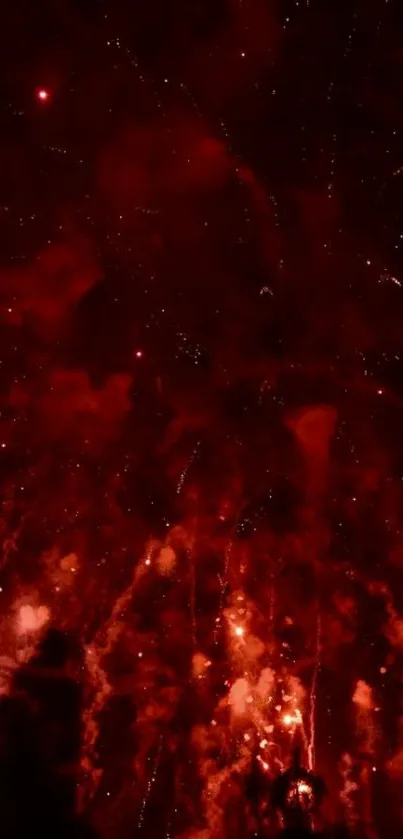 Red fireworks burst brightly in the night sky.