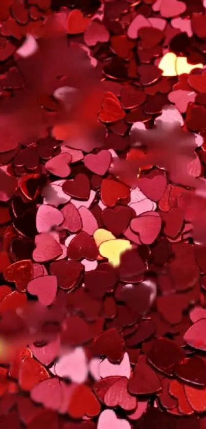 Red and pink heart shapes scattered on a vibrant wallpaper.