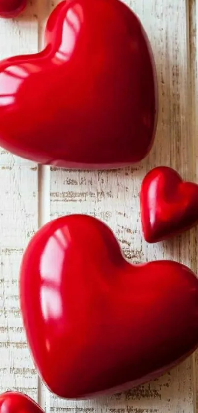 Glossy red hearts on a rustic wooden background.