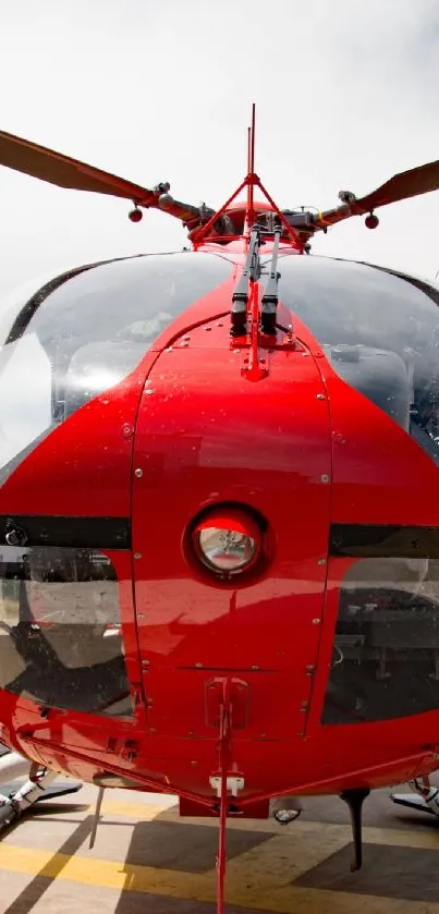 Red helicopter on airfield, close-up view with vibrant colors.