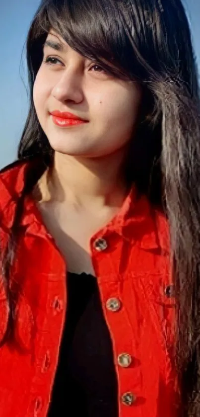 Person wearing a red jacket outdoors with a clear blue sky.