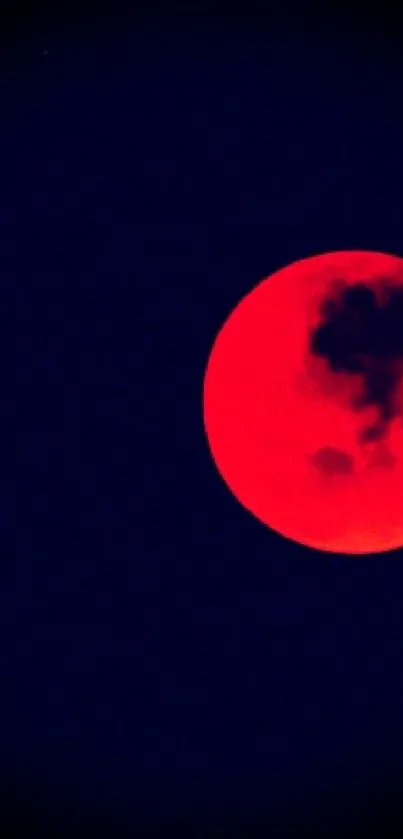 Red moon against a deep dark sky, creating a vibrant wallpaper.