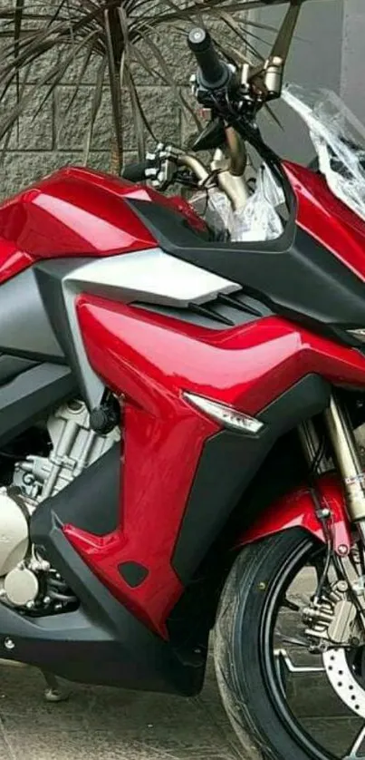 Red motorcycle with sleek design on pavement background.