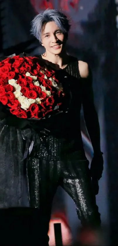 Man holding a large bouquet of red roses in a dark setting.