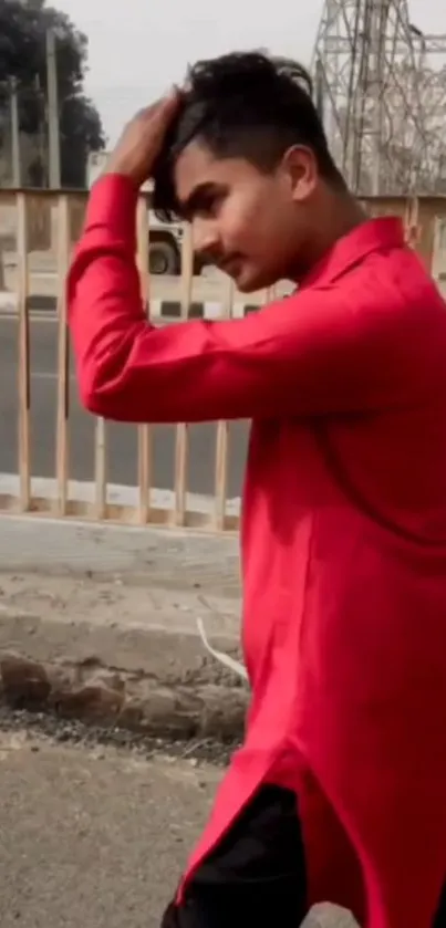 Man in vibrant red shirt walking along the street.