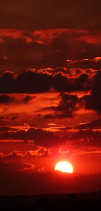 Vibrant red sunset with clouds in the sky.