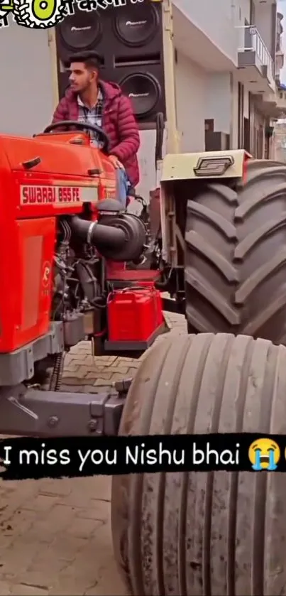 Red tractor on a village street with a man in the driver's seat.