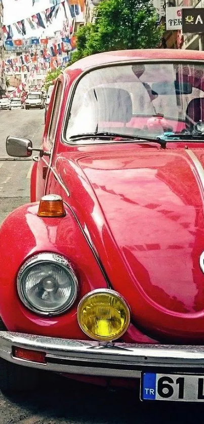 Red vintage car on a lively street with colorful flags.