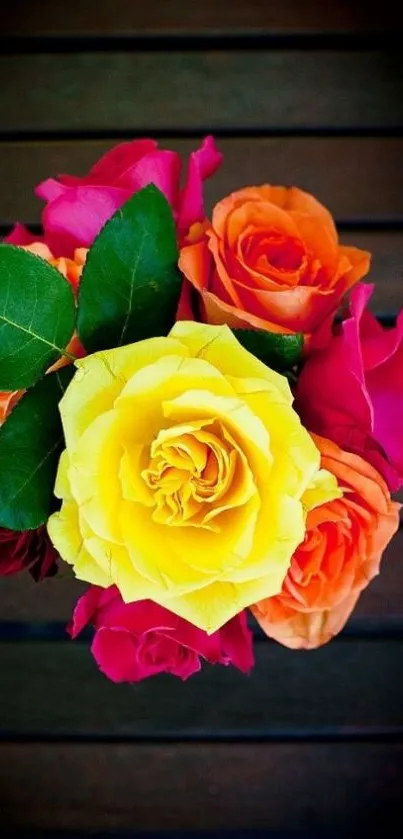 Vibrant bouquet of roses with yellow, orange, and pink blooms on a dark background.