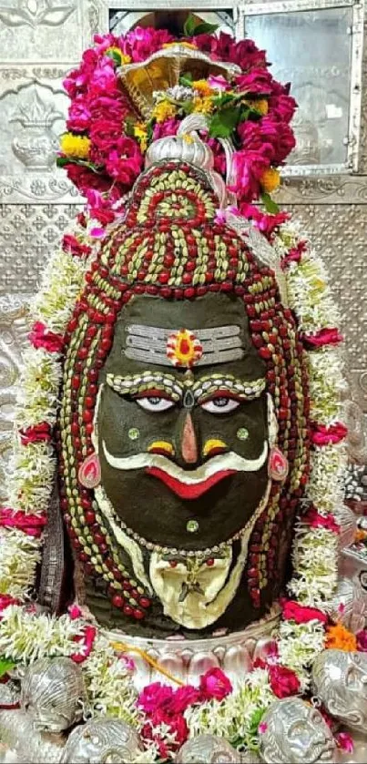 Shivling with vibrant floral decorations in a temple setting.