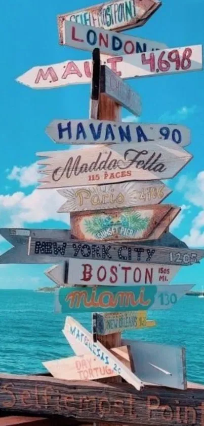 Colorful signpost by the sea under blue sky.