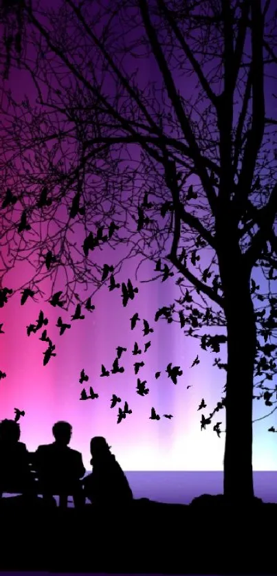 Silhouette of a tree and birds against a vibrant purple gradient sky.