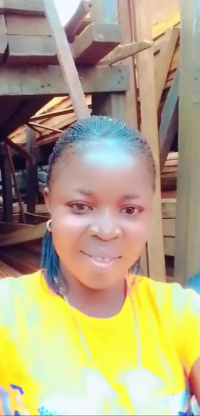 Smiling person in orange shirt with wood backdrop.