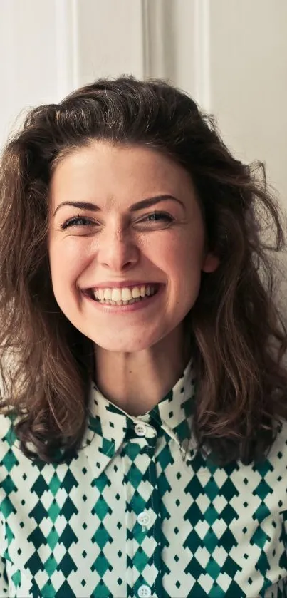 Smiling woman in a green and white patterned shirt.