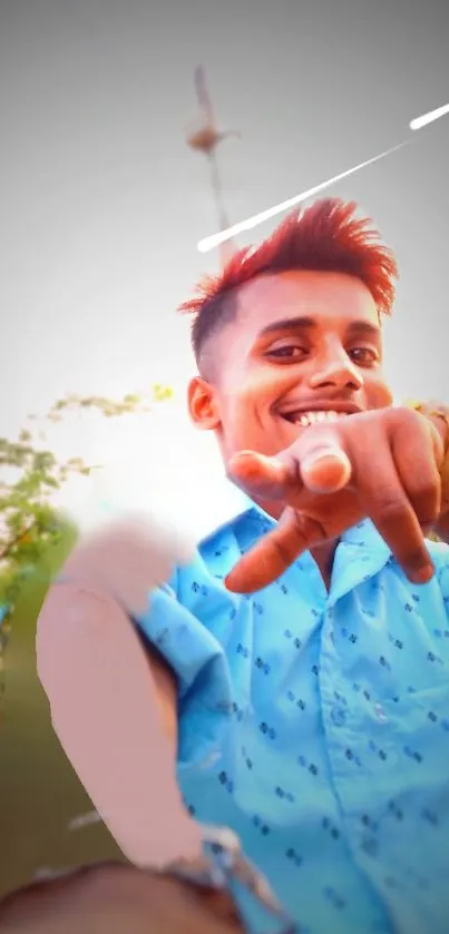 Smiling young man in blue shirt, outdoor setting, vibrant phone wallpaper.