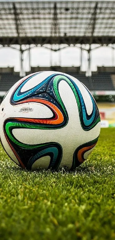 Soccer ball resting on green grass at a stadium with open sky.