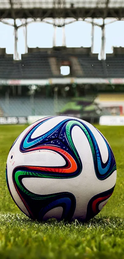 Colorful soccer ball on a green field in a stadium setting.