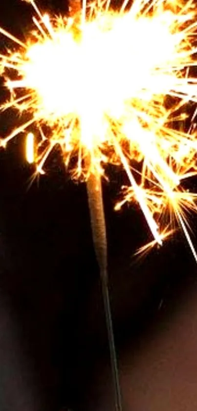 Bright yellow sparkler light on a dark background.