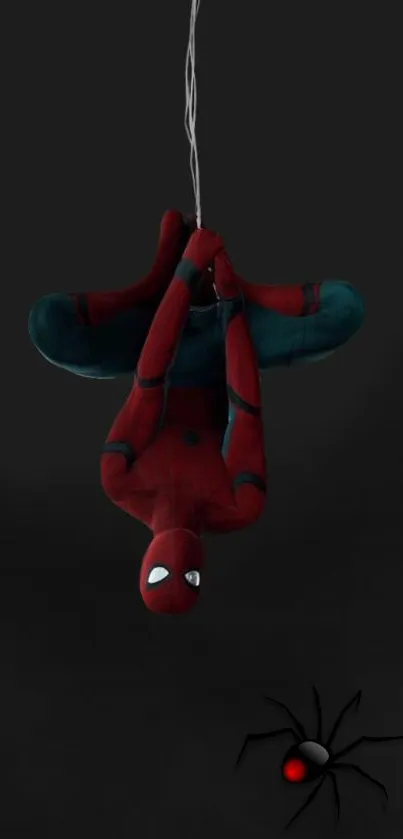 Spider hero in red suit hanging upside down on black background.