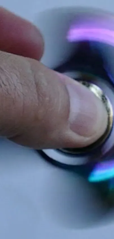 Close-up of a hand spinning an LED-lit fidget spinner.