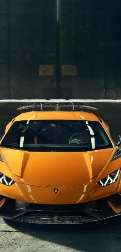 Orange sports car in dimly lit warehouse.