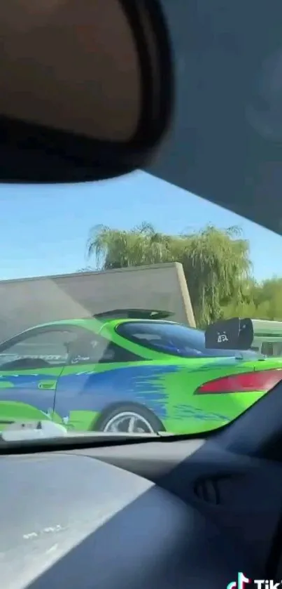 Vibrant green and blue sports car seen from a vehicle interior.