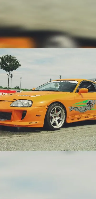 Orange sports car with dynamic design on track.