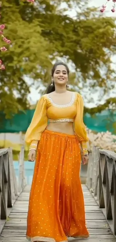 Woman in orange attire on bridge with flowers.