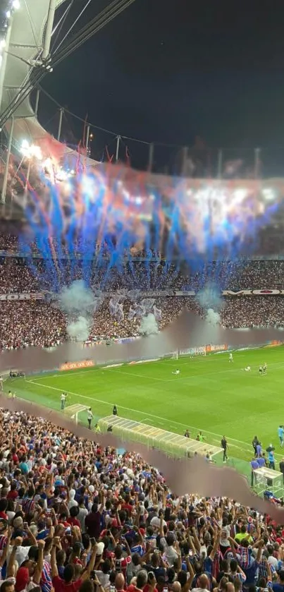 Vibrant stadium during night football match with fireworks and cheering crowd.