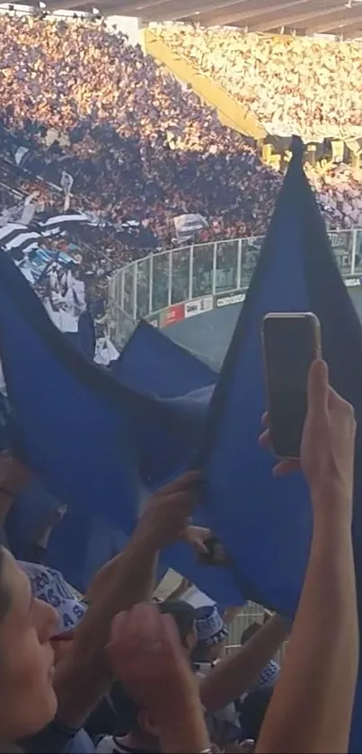 Blue flags waving in stadium crowd during football match.