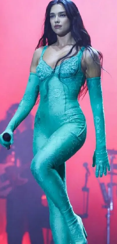 Woman in teal outfit performing on stage with colorful lights.