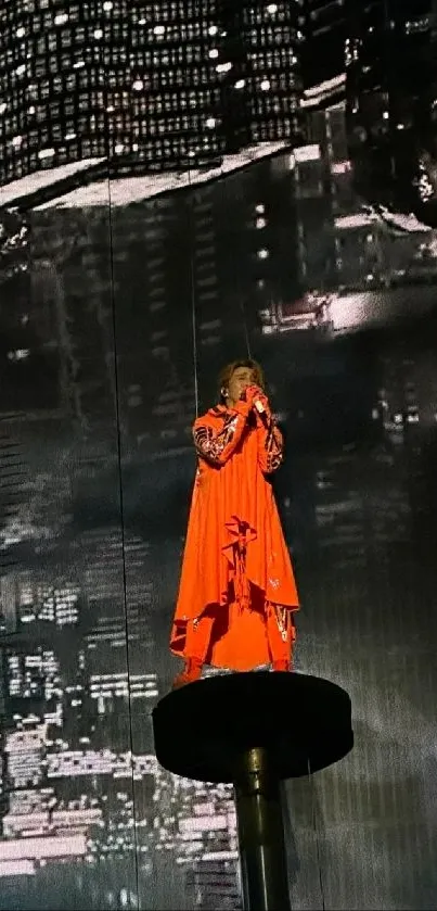 Performer in orange outfit against cityscape backdrop.