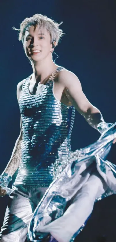 Performer in shiny silver attire on stage, dynamic pose.