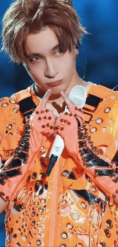 Vibrant performer in orange outfit on stage, captivating and stylish.