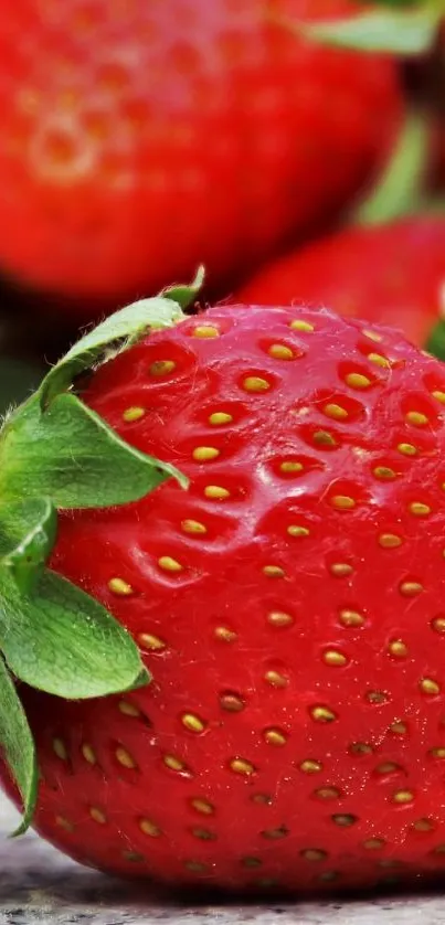 Fresh red strawberries on a stone surface, vibrant and juicy.