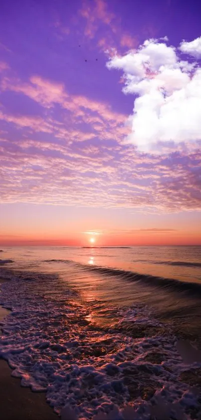 Purple sunset beach with ocean waves and clouds.