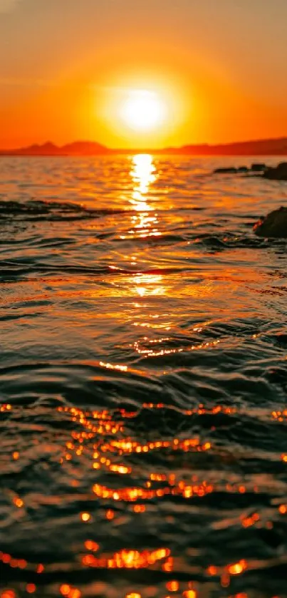 Vibrant orange sunset over the ocean with waves and glowing horizon.