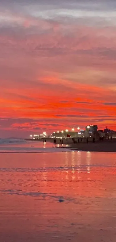 Vibrant sunset beach with orange sky reflected on calm sea.