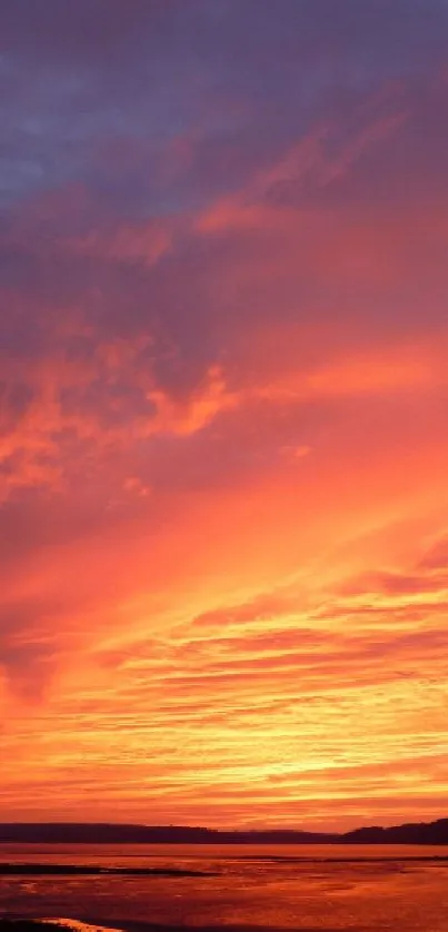 Vibrant orange sunset over serene beachscape