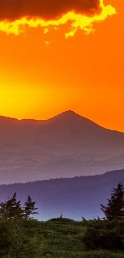 Vibrant orange sunset over mountain silhouette with clear sky.