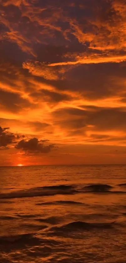 A stunning sunset over a calm ocean with vibrant orange skies and gentle waves.