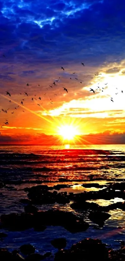 Vibrant sunset over ocean with birds flying in the sky.