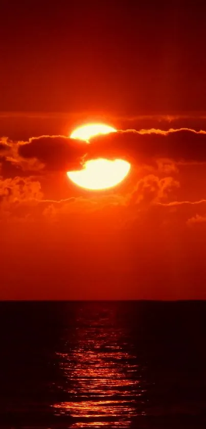 Vibrant sunset over the ocean with fiery red hues.