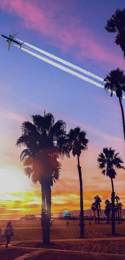 Airplane soaring over sunset beach with palm trees against a colorful sky.